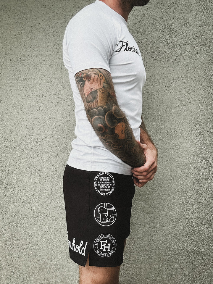 Side view (right) of Flowhold’s Defeater Fight Shorts and rash guard set worn by model