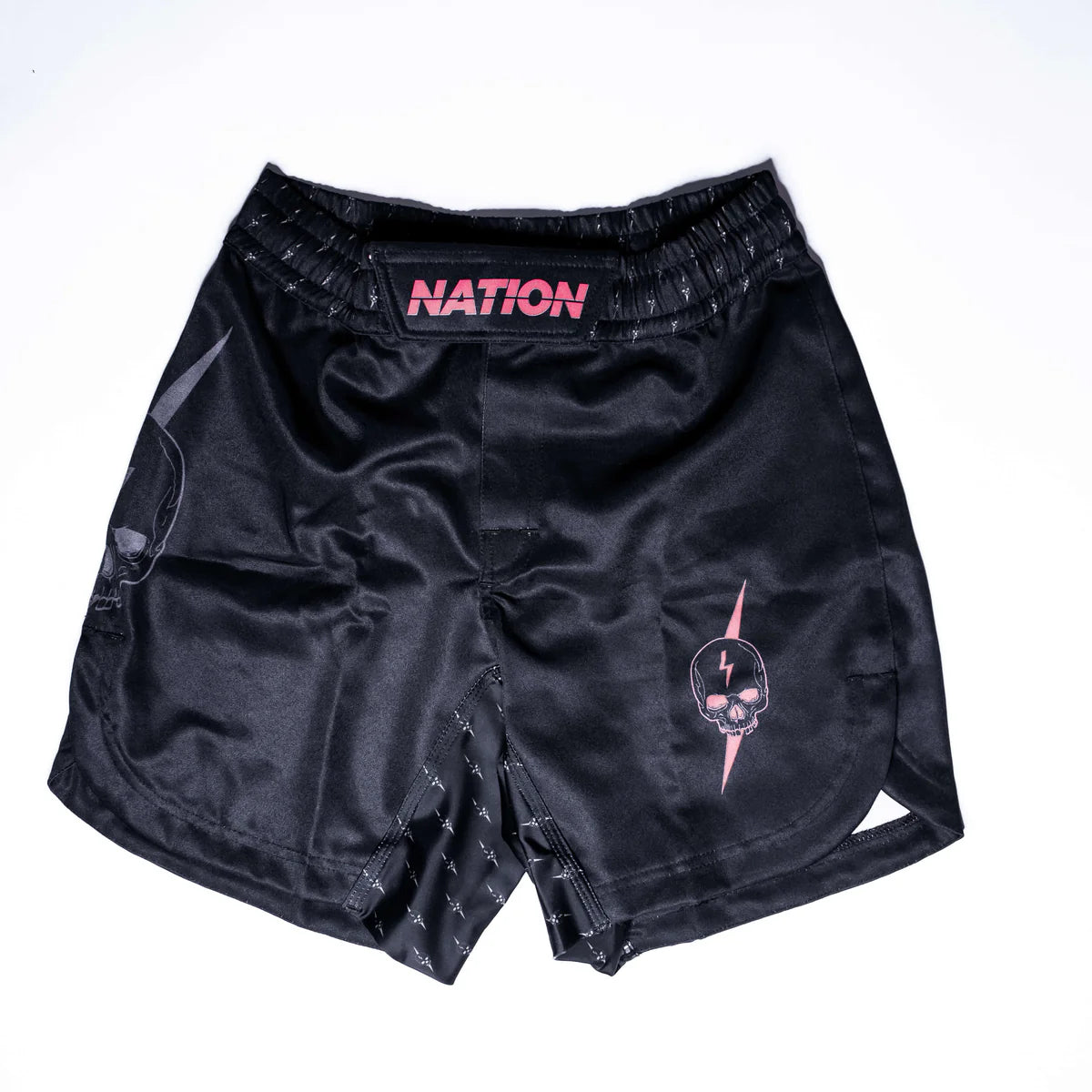 Front view of Death Cuddle Cult BJJ Fight Shorts by Nation Athletic with pink skull logo detail – black No-Gi shorts for MMA and grappling