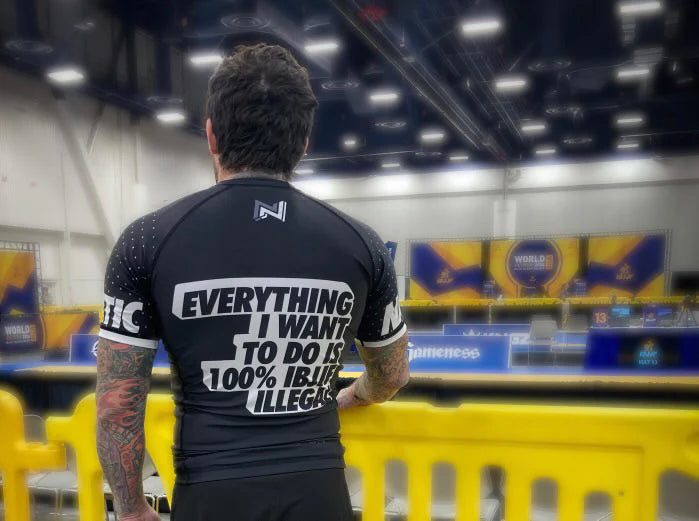 Back view of model wearing Nation Athletic IBJJwhite Ranked Rash Guard in stadium – Short Sleeve, compression fit BJJ competition rash guard