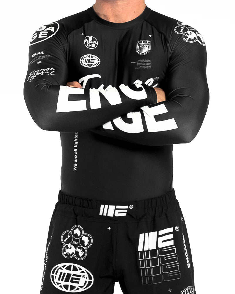 Front view of Engage Billboard long Sleeve with logo in the sleeve details Rash Guard Black worn by model