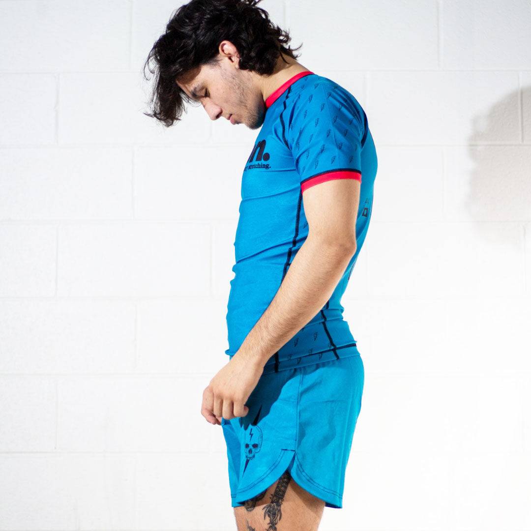 Side view of model wearing Nation Athletic’s Murder Yoga Blue BJJ set rash guard and Shorts – durable No-Gi grappling shorts for Jiu Jitsu and MMA