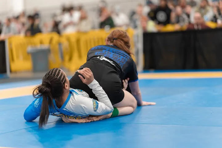 Live action of a fighter in a competition wearing a Nation Athletic IBJJF blue Ranked Rash Guard – Short Sleeve, compression fit BJJ competition rash guard